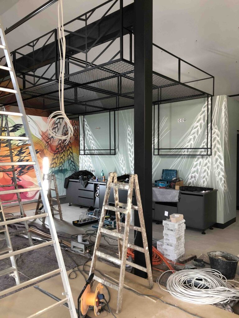 Bild von Bäckerei in der eine Montage passiert. Mit Kabeln und Leitern im Bild von den Aufbauarbeiten.